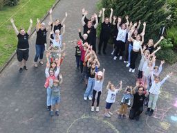 Gruppenfoto vom KiBiCamp: Die Kinder und Teamer stellen eine "10".